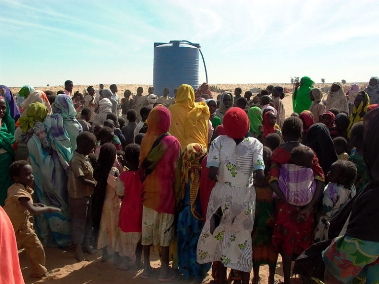 Displaced_persons_with_water_tank_in_Genenia,_West_Darfur_in_2007